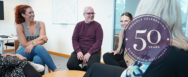 A group of colleagues laughing around a table.