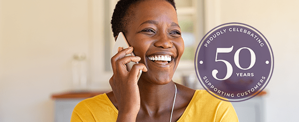 A woman laughing whilst on the phone at home.