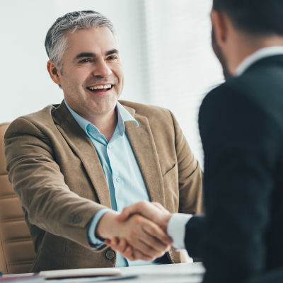 Two men in suits shaking hands 547x547