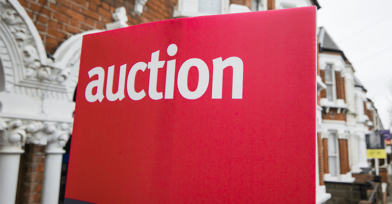 A close up of an auction sign on a street.