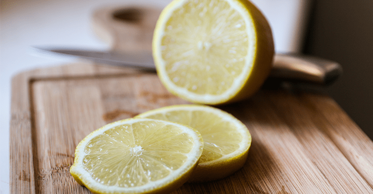 A lemon sliced into pieces on a chopping board.