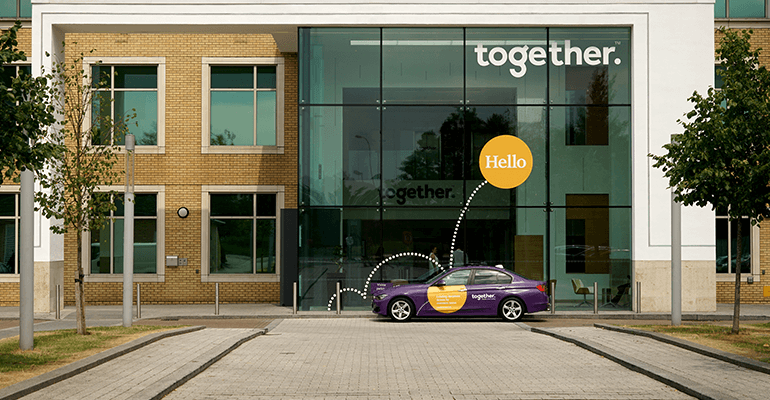 A long shot of Togethers building with a company car in front.