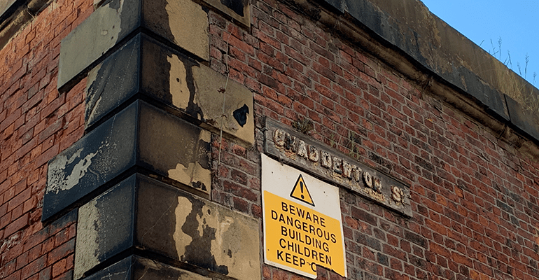 corner of red brick building with chadderton street sign - l