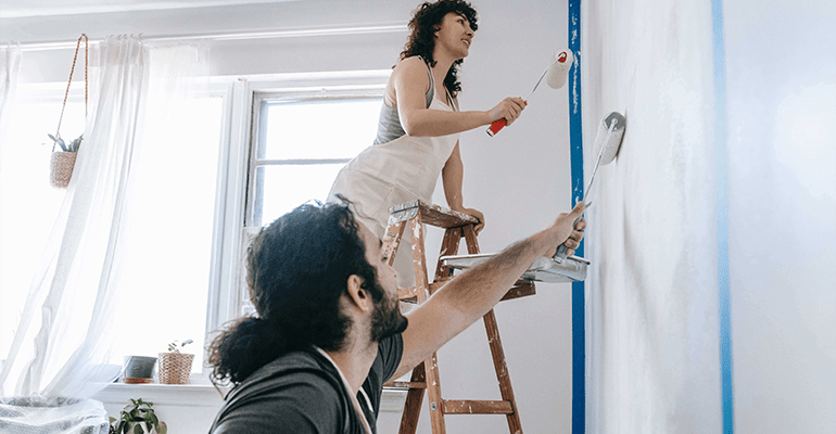 couple painting a wall - l