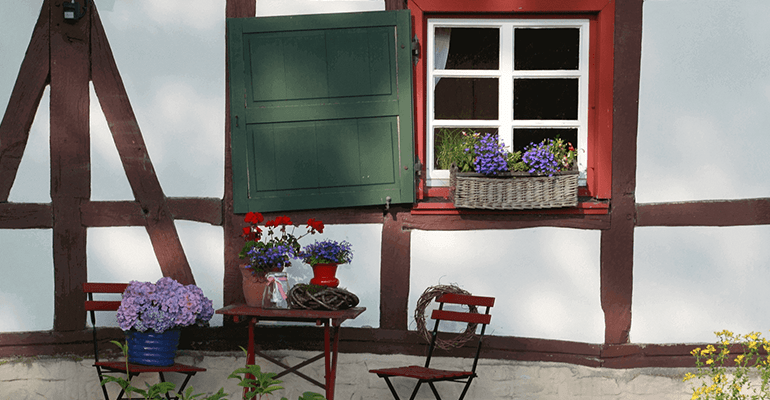 exterior of a mock tudor house with flower baskets outside - l