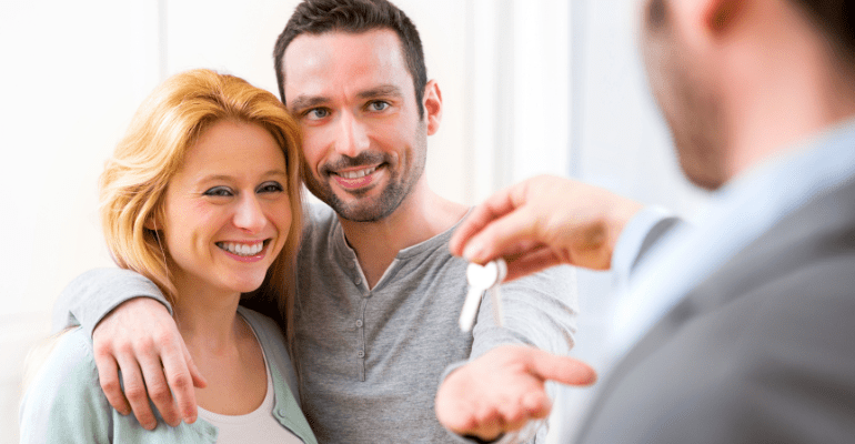 Happy couple receiving house keys.