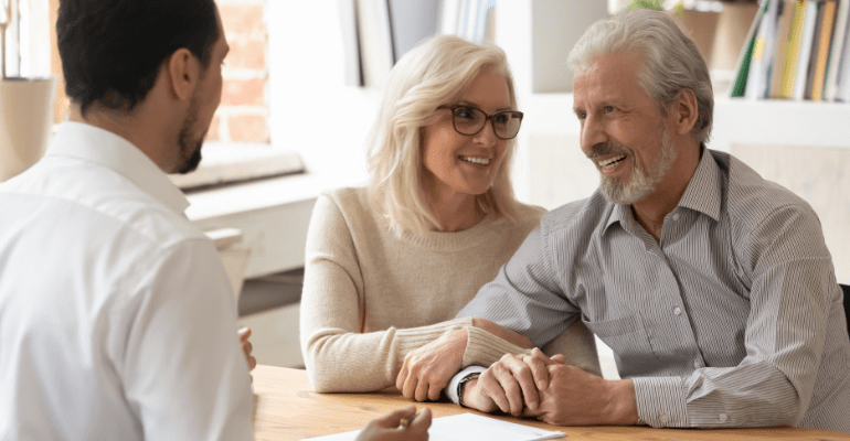 Happy older couple talking to a consultant.