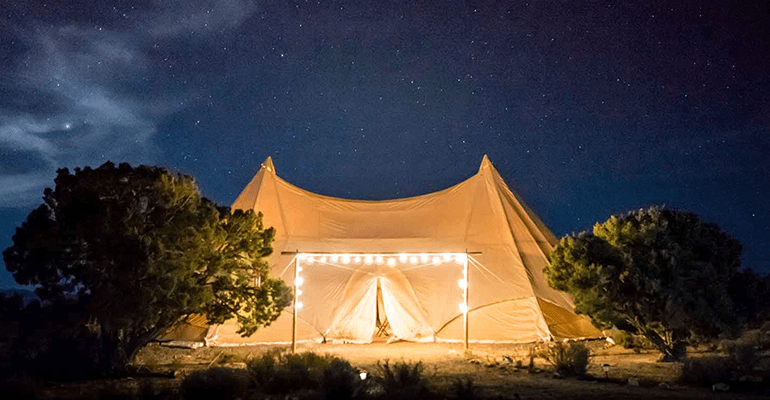 large tent framed with large fairy lights under a stary sky - l