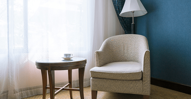 low back chair next to a dark wooden round table - l