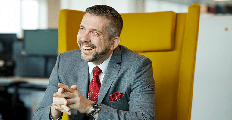 Man in a grey suit with short grey hair