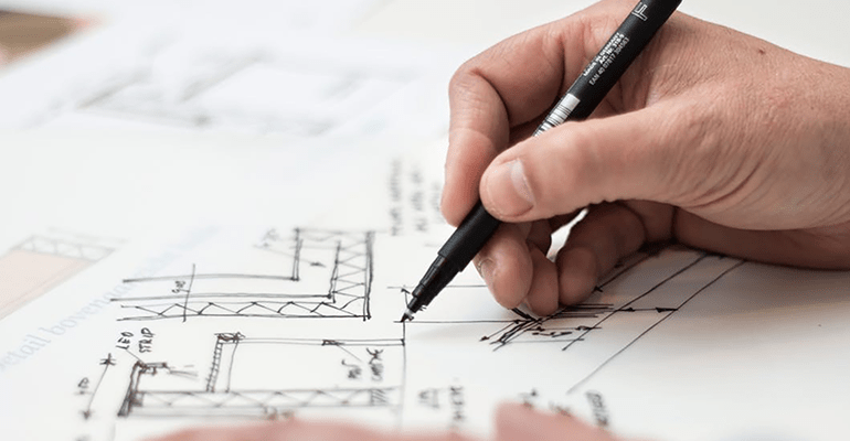 person working on technical architect drawings - l