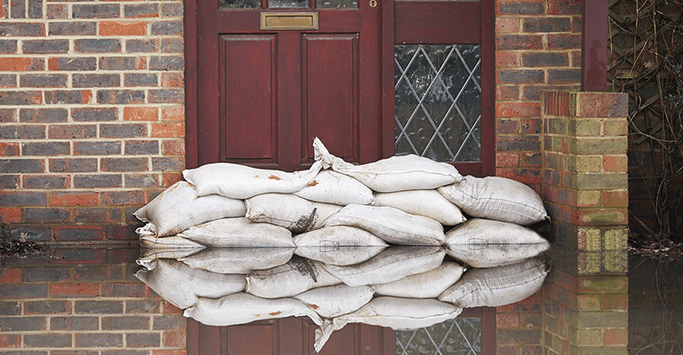 red front door with sandbags protecting the property from flooding - l