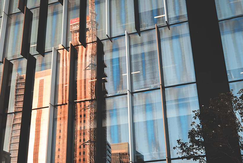 reflection of a tower block being built in a tall office building - l