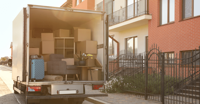 Removal van with furniture outside flats.