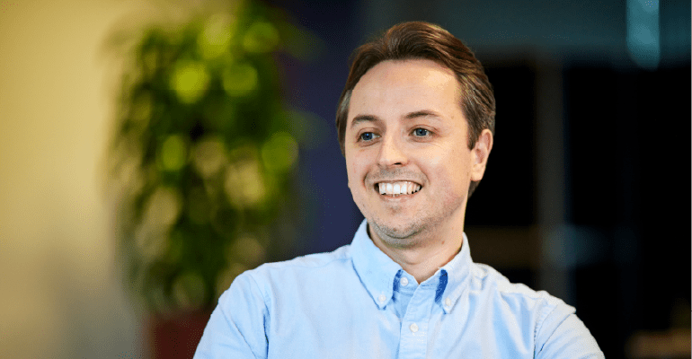 Smiling man in blue shirt.