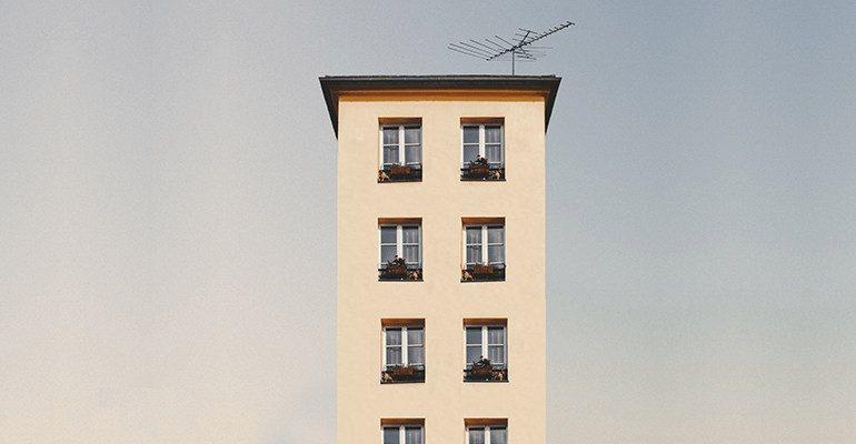 tall white building with plant boxes on each window - l