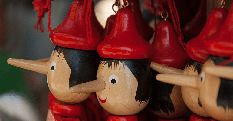 wooden dolls with long noses wearing red hats and jackets - l