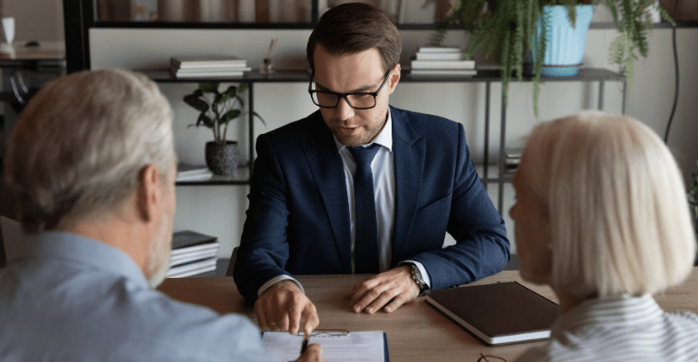 Young solicitor giving advice to older couple.