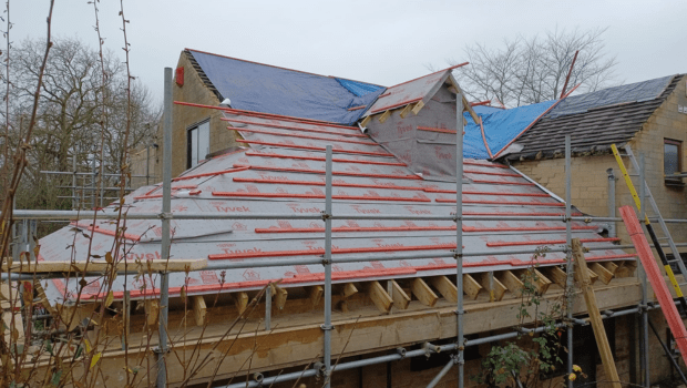 Unfinished roof on a house with scaffolding.