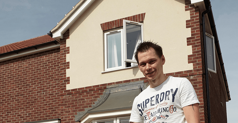 man smiling in front of a house - l