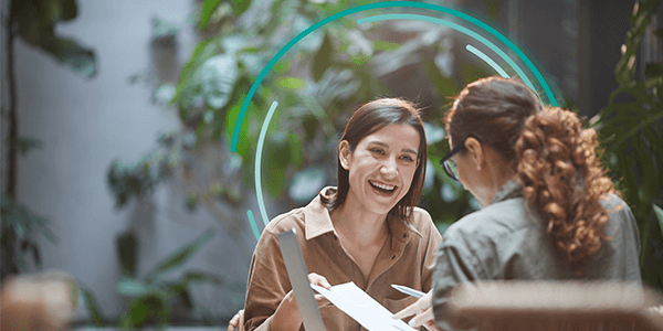 Two women with brown hair smiling and chatting - large