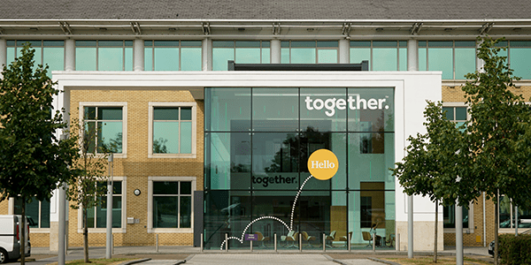 Front of an office building with the together logo in the window.