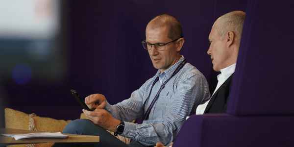 Two colleagues sat looking at a mobile phone - l