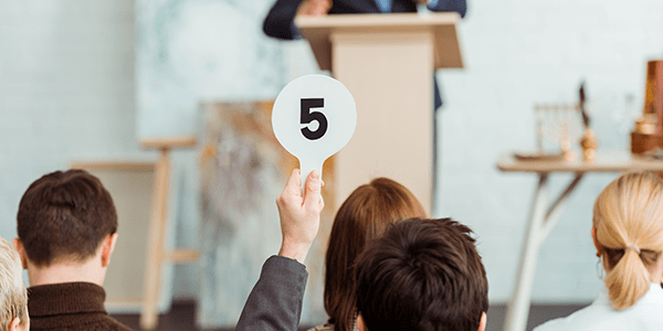 A man making a bid at auction.