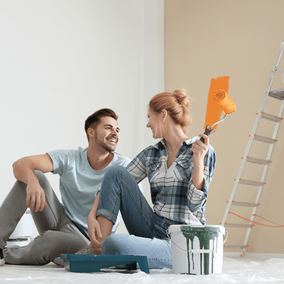 Happy couple with paint planning home repair indoors - l