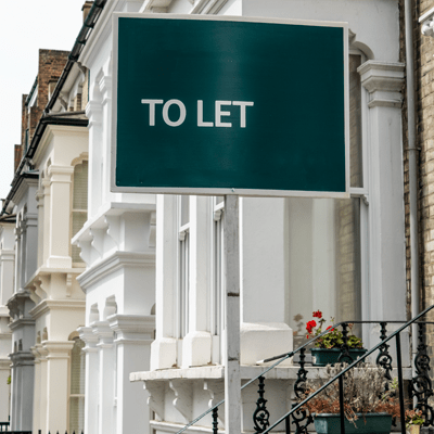 An estate agency To Let sign board outside white townhouse - s