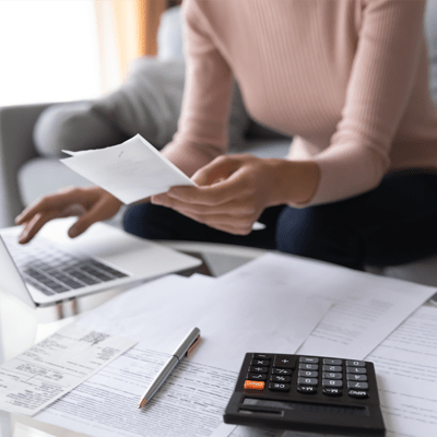 economical woman working on laptop and calculator - l