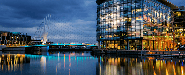 A long shot of the trinity bridge in Manchester at night.