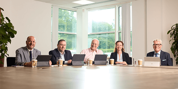 A group of people smiling whilst sat at a table