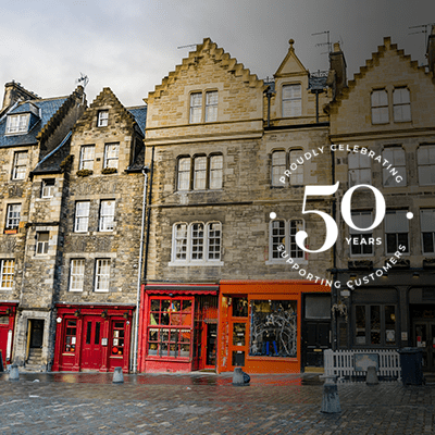 A wide shot of terraced apartments with shops below them.