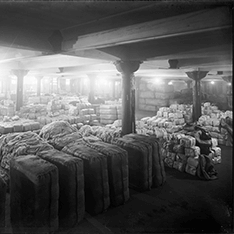 A black and white wide shot of people working with machines.