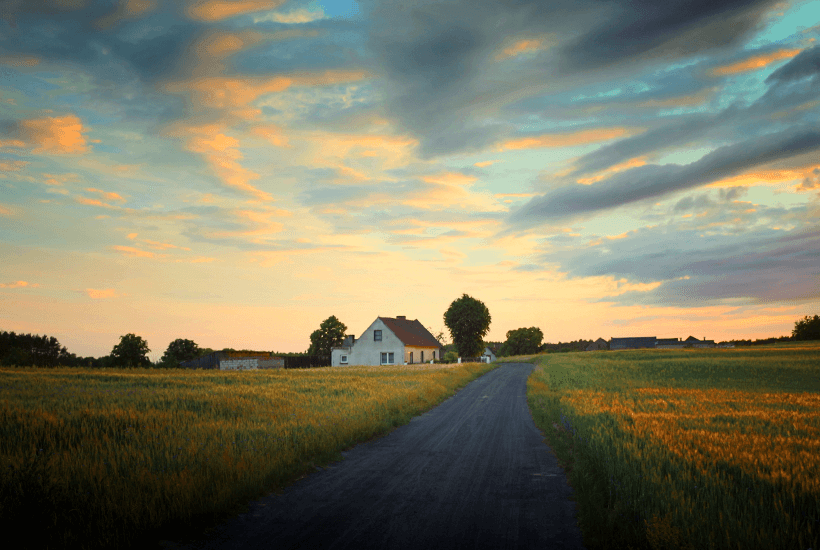 A farmhouse in the middle of a field.