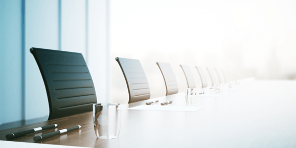 Formal desk chairs in a line along a desk.