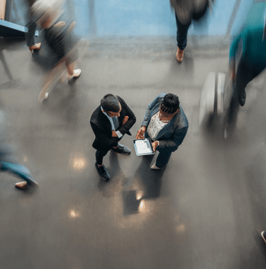 two people looking at a tablet in an office - l