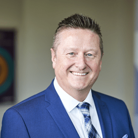 A man in a blue suit with spikey hair.