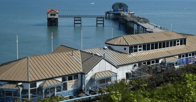 A building that goes into a pier in the ocean.