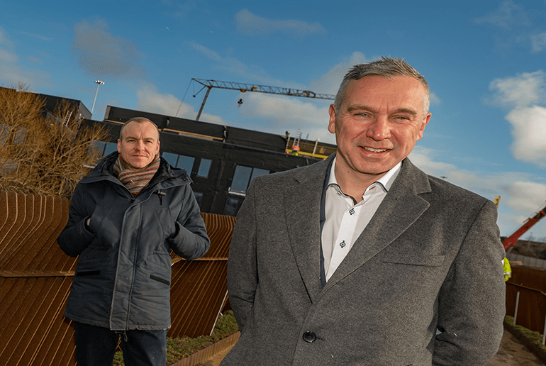 entrepreneur and businessman stood outside a building development