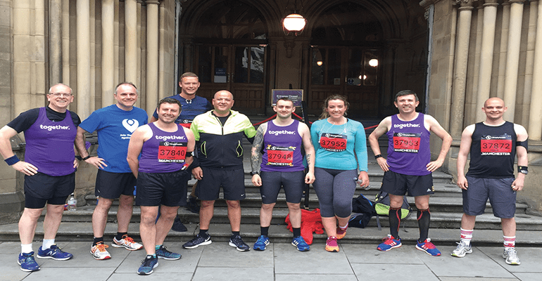 group of runners stood outside a building 