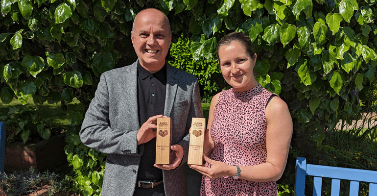 Male and female dressed smartly both holding award - m l