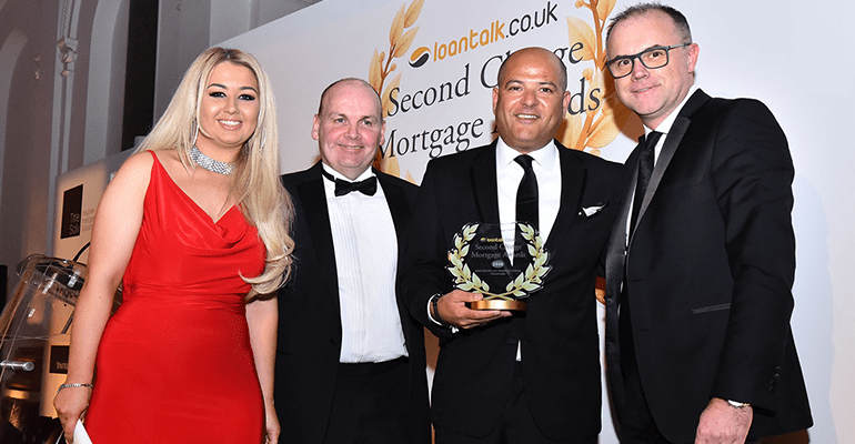 three men in blakc tie suits and a woman in a red dress at an awards ceremony - l