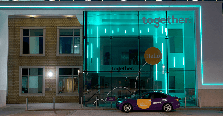 together office and together car at night with blue lights on inside the building - l