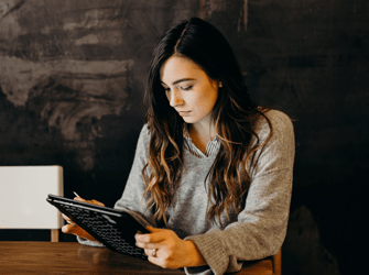 Brunette lady looking down at an electronic device