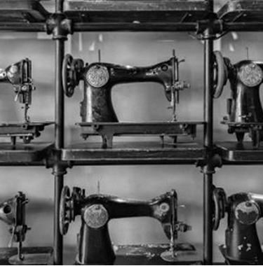 Shelves with sewing machines stacked on top of each other.