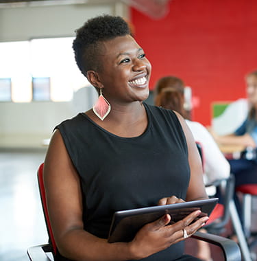 women in office smiling at colleague