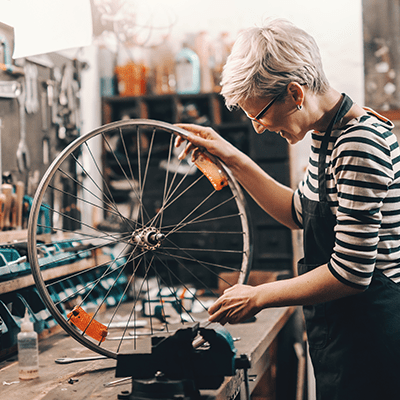 lady mechanic wearing a striped shirt working in a cycling shop 