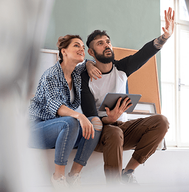 man and woman planning with tablet indoors at home - l